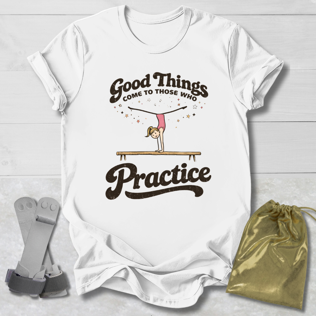 White t-shirt with 'Good Things Come to Those Who Practice' graphic on a wooden surface with socks and a drawstring bag.
