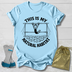 Light blue t-shirt with graphic design and text, socks, and drawstring bag on a light wooden surface.