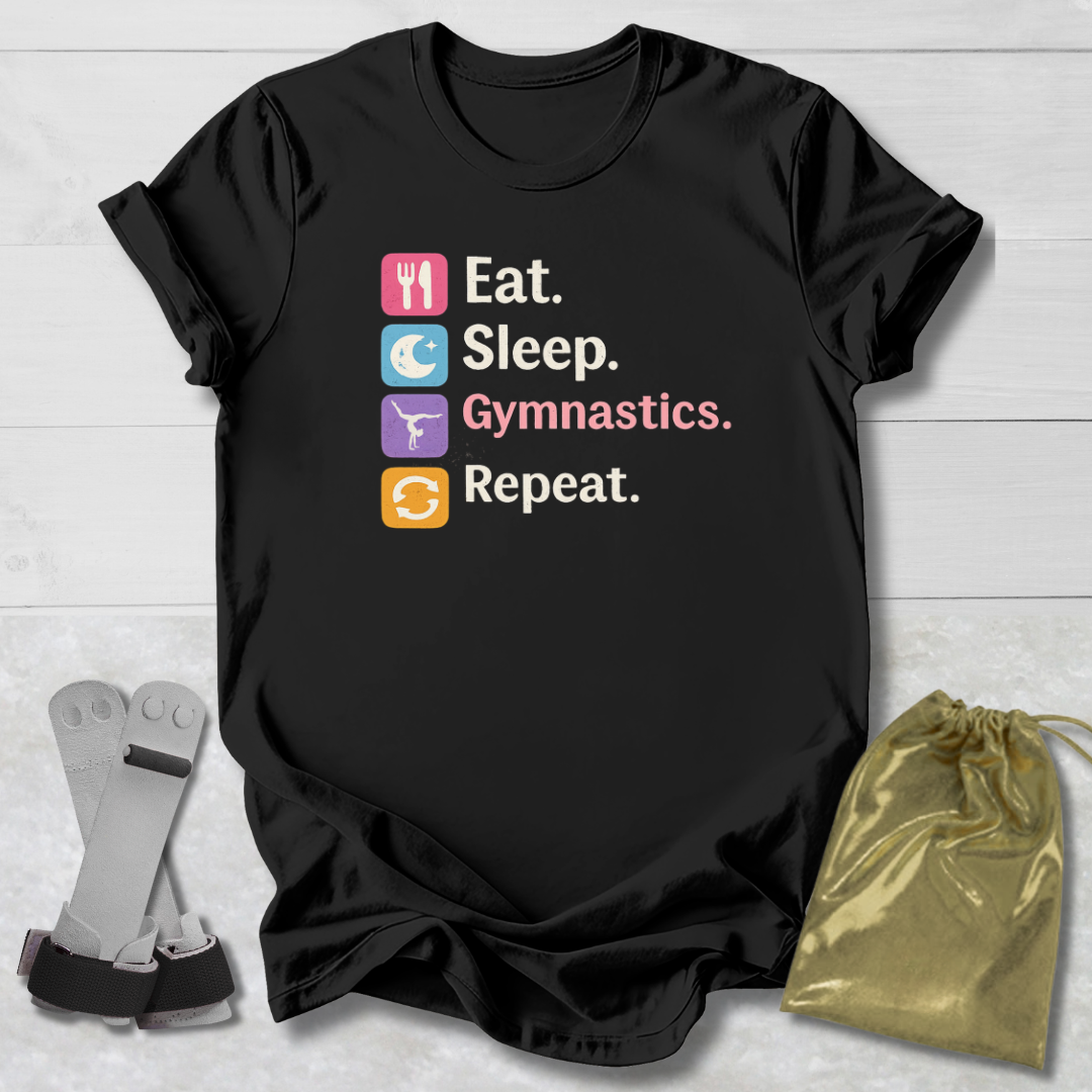 Black t-shirt with 'Eat. Sleep. Gymnastics. Repeat.' text and icons on a wooden surface with socks and a drawstring bag.