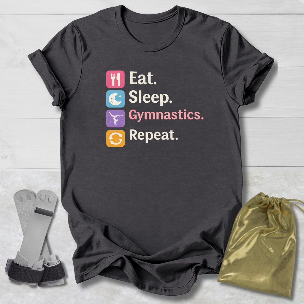 Black t-shirt with 'Eat. Sleep. Gymnastics. Repeat.' text and symbols on a light wooden surface.