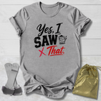 Gray t-shirt with 'Yes, I saw that' text on a wooden surface with socks and a drawstring bag.