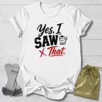 White t-shirt with 'Yes, I Saw That' text on a light wooden surface with socks and a drawstring bag.