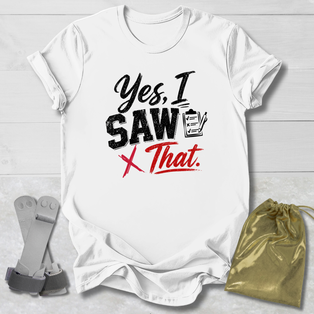 White t-shirt with 'Yes, I Saw That' text on a light wooden surface with socks and a drawstring bag.