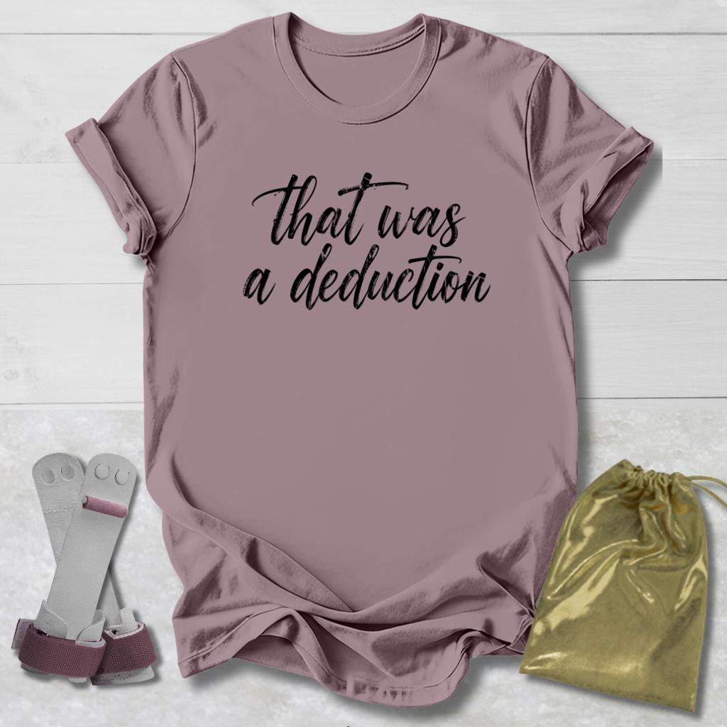 Mauve t-shirt with 'That was a deduction' text, socks, and drawstring bag on a light wooden surface