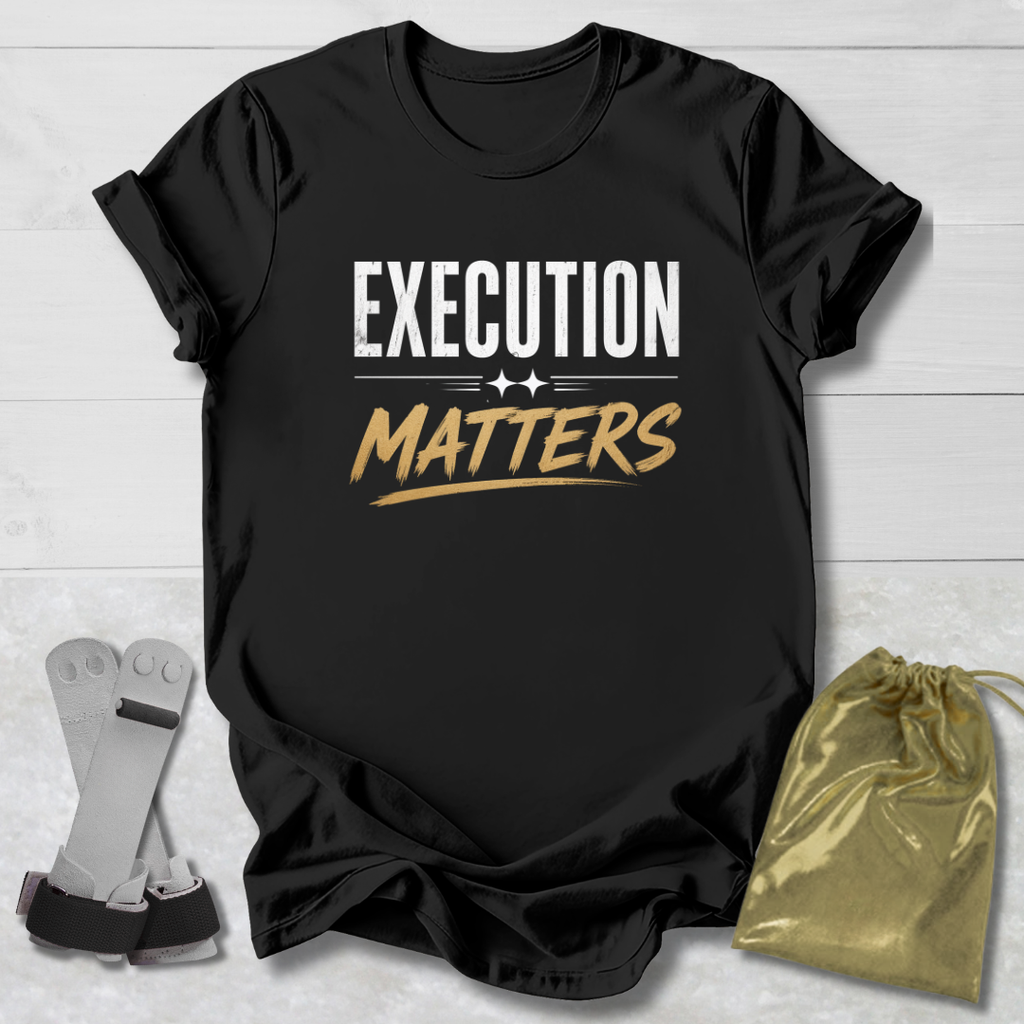 Black t-shirt with 'Execution Matters' text on a wooden surface with socks and a drawstring bag.