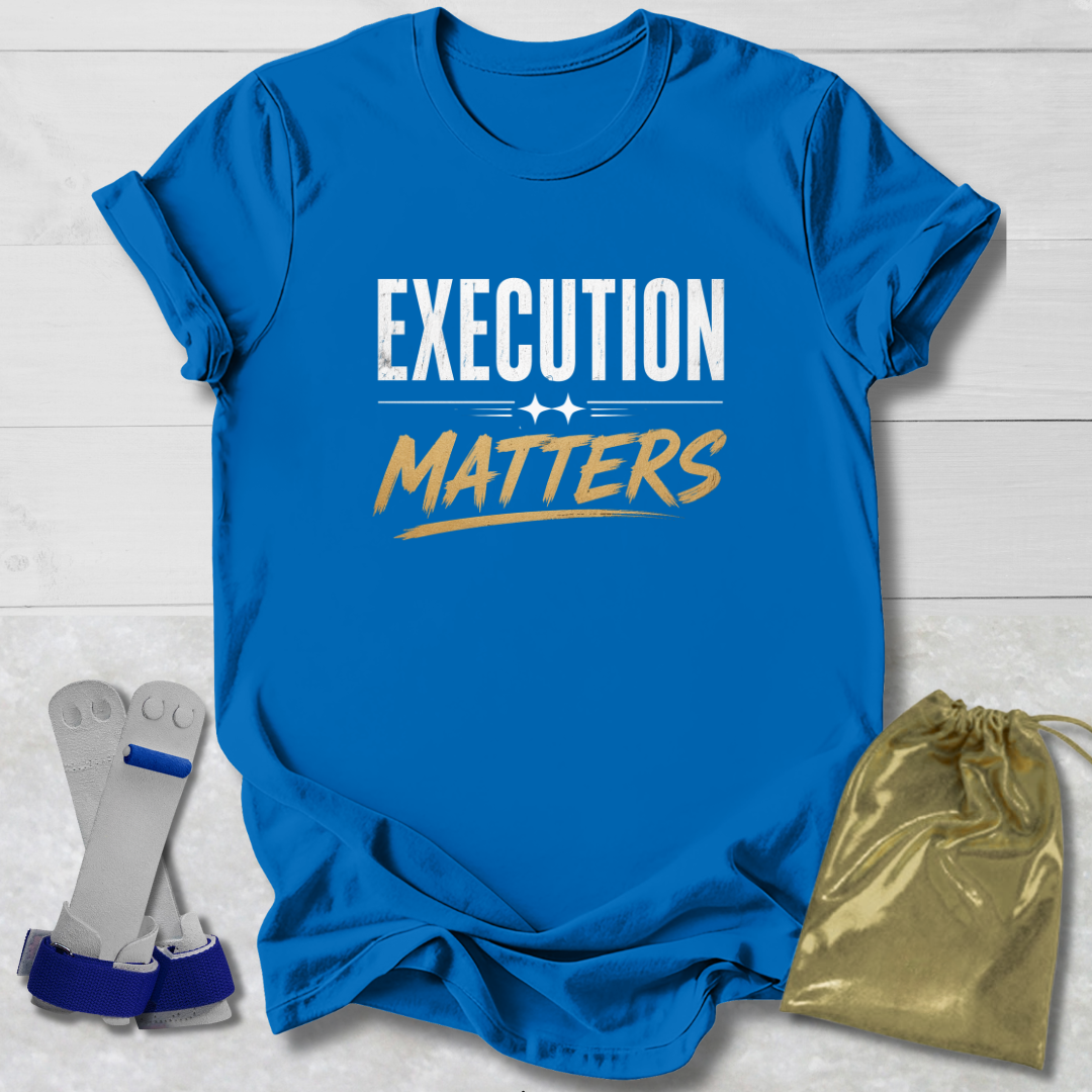 Blue t-shirt with 'Execution Matters' text on a wooden surface with socks and a drawstring bag.