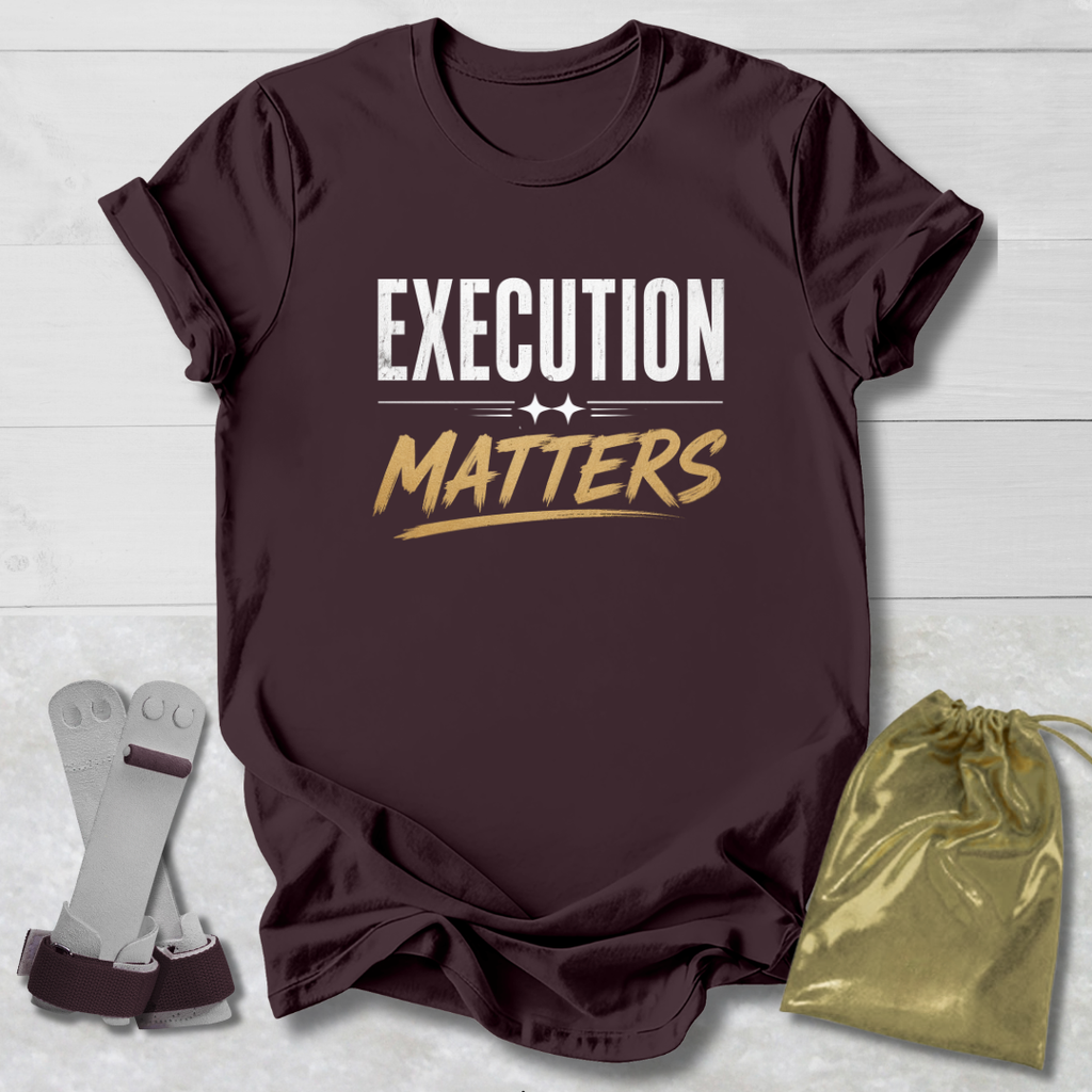 Maroon t-shirt with 'EXECUTION MATTERS' text on a light wooden surface with socks and a drawstring bag.