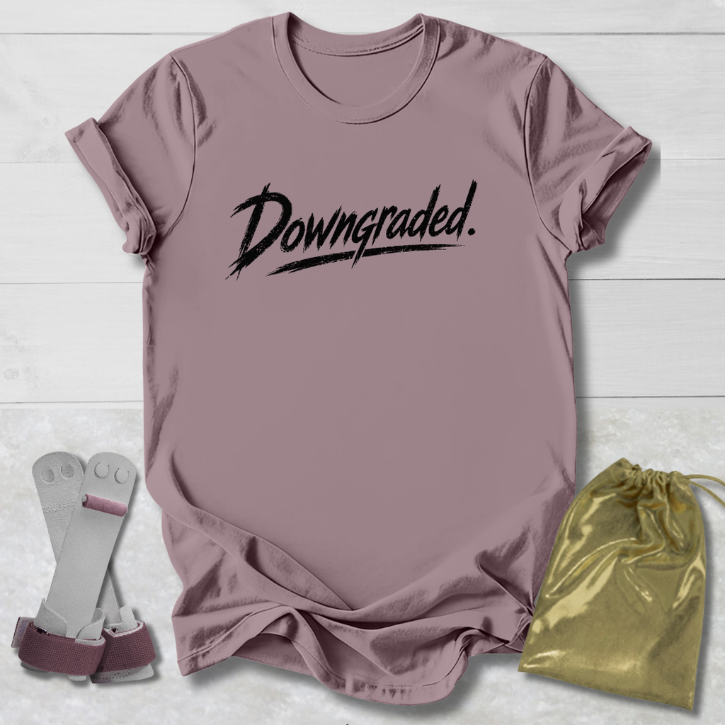 Mauve t-shirt with 'Downgraded' text, socks, and a drawstring bag on a light wooden surface.