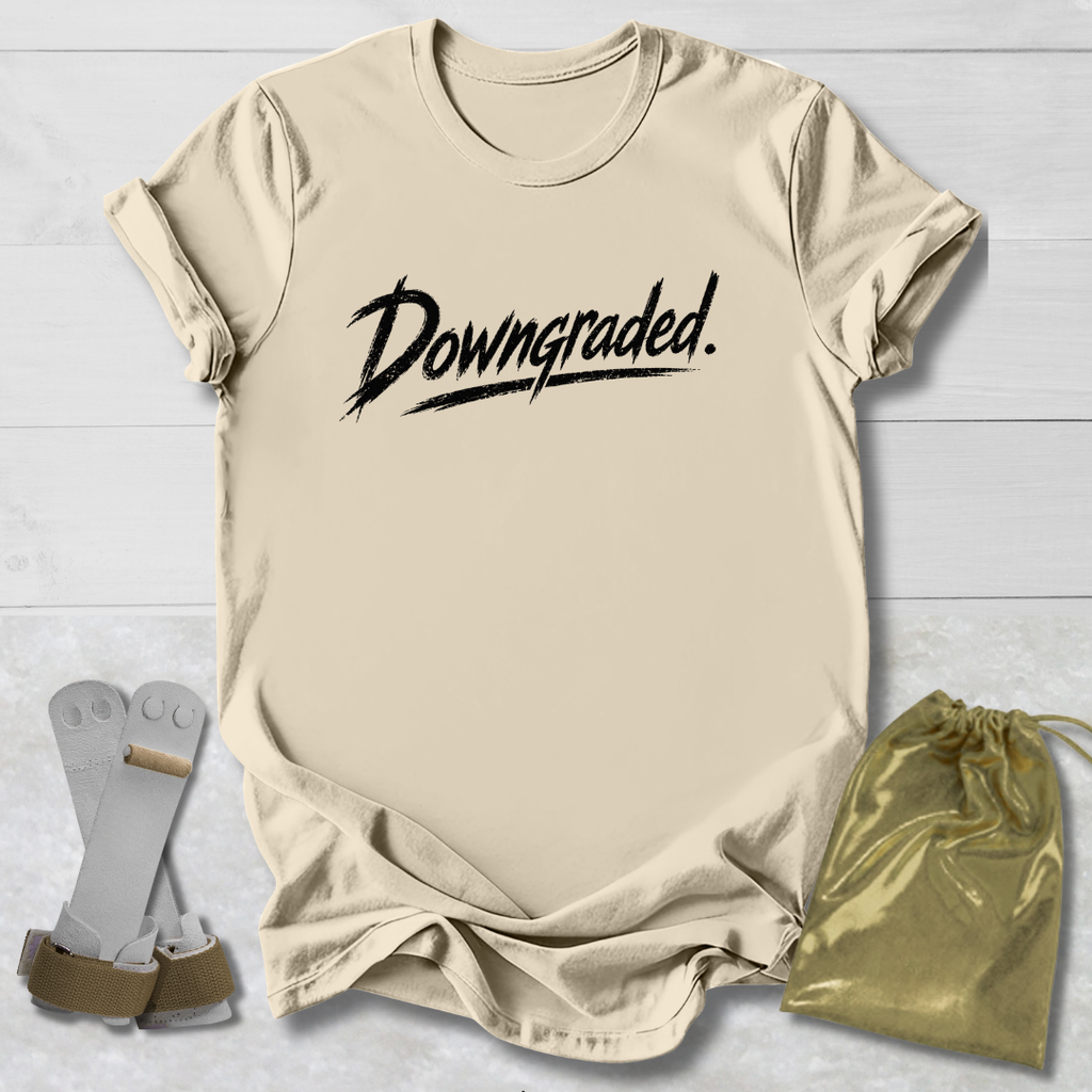 Beige t-shirt with 'Downgraded' text, socks, and drawstring bag on a light wooden surface