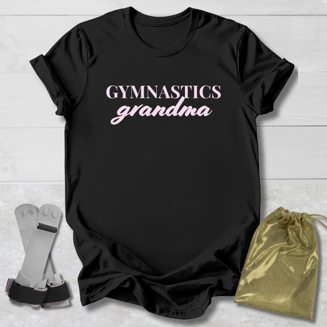 Black t-shirt with 'Gymnastics grandma' text on a light wooden surface with socks and a drawstring bag.