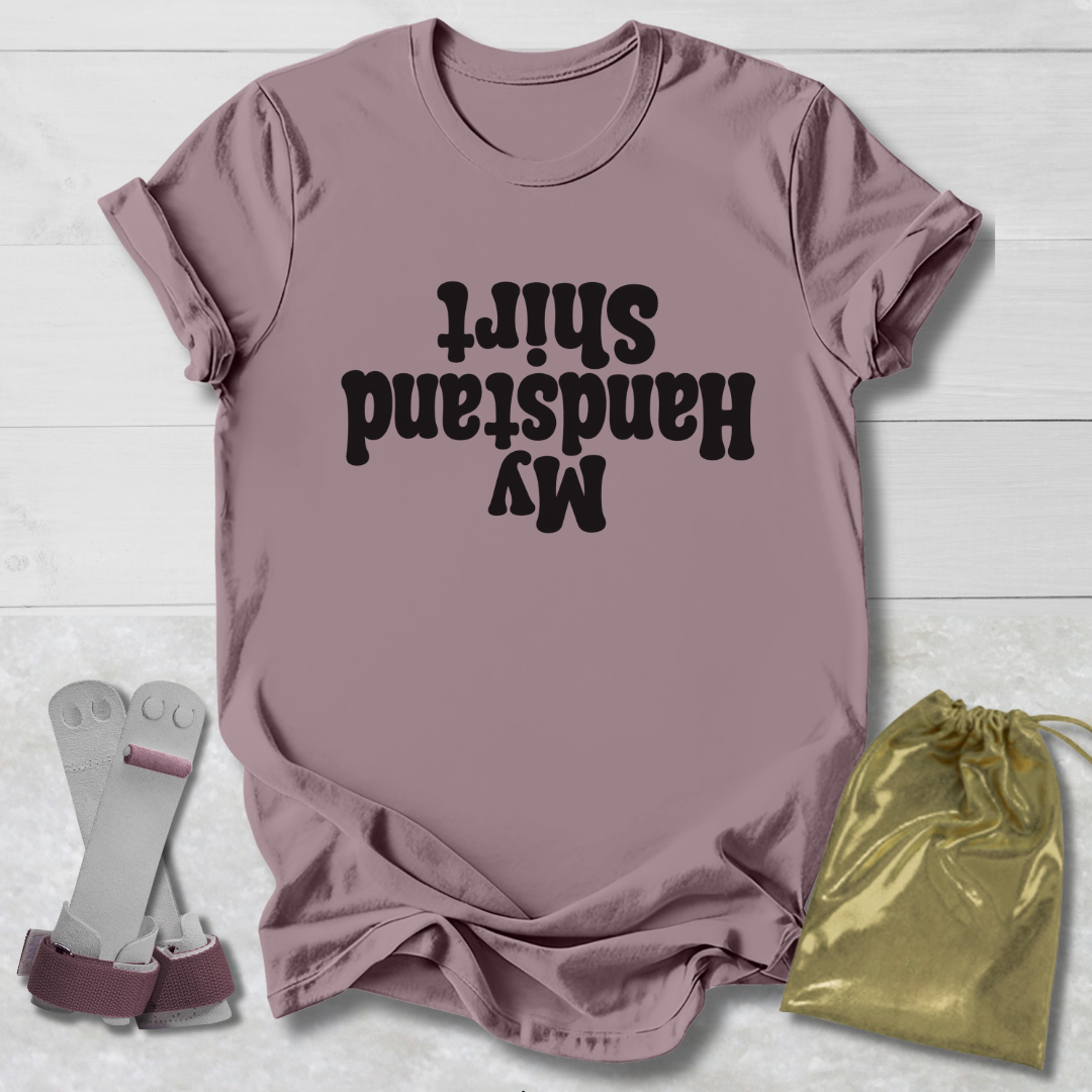 Mauve t-shirt with My Handstand Shirt text, socks, and drawstring bag on a light wooden surface