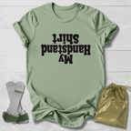 Green t-shirt with  My Handstand Shirt text, socks, and drawstring bag on a light wooden surface