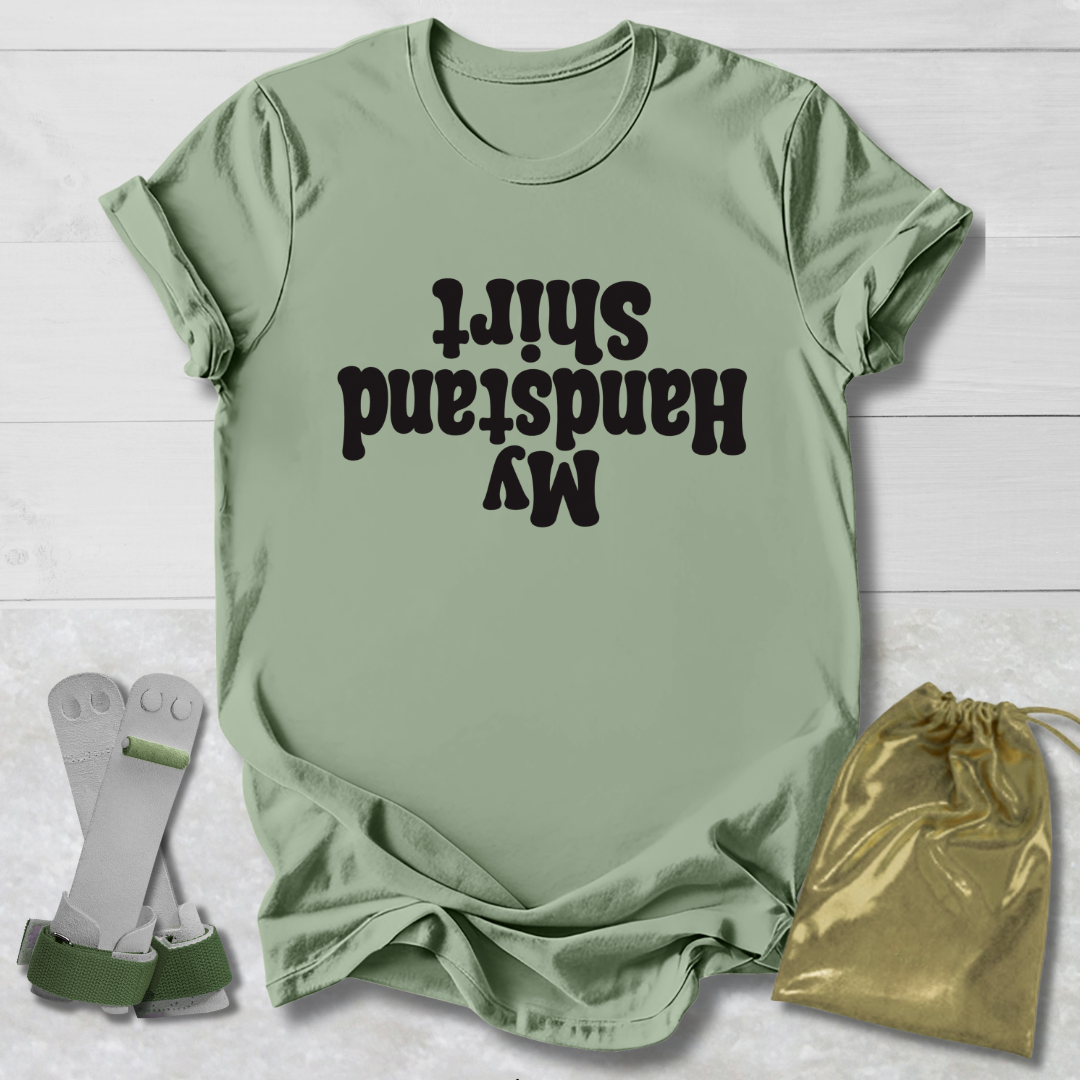 Green t-shirt with  My Handstand Shirt text, socks, and drawstring bag on a light wooden surface