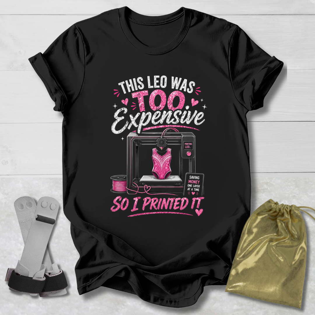 Black t-shirt with pink and white graphic and text on a light wooden surface.