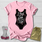 Pink t-shirt with black funny gymnastics leotard graphic and text, socks, and drawstring bag on a light wooden surface.