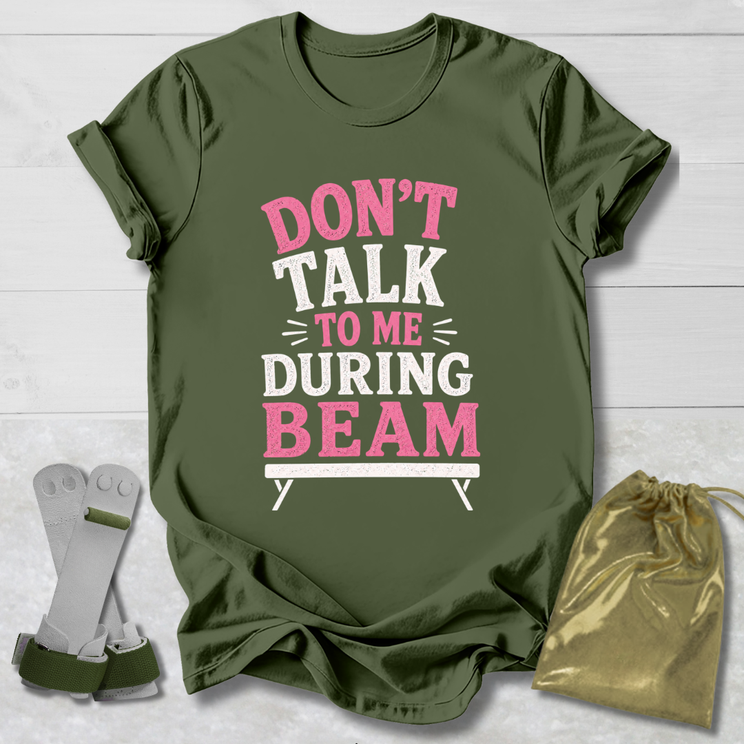 Green t-shirt with pink and white text on a wooden surface, accompanied by socks and a drawstring bag.