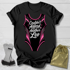 Black t-shirt with a funny gymnastics leotard  graphic and text, socks, and a drawstring bag on a light wooden surface.