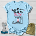 Light blue t-shirt with graphic design and Leotard prices made me do this gymnastics text, placed on a wooden surface with socks and a drawstring bag.