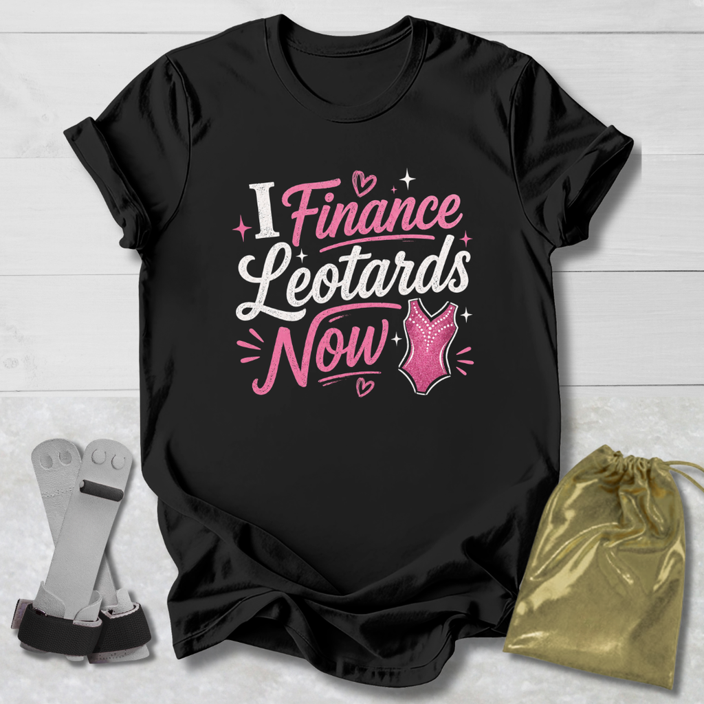 Black t-shirt with pink and white text on a light wooden surface, accompanied by socks and a gold drawstring bag.