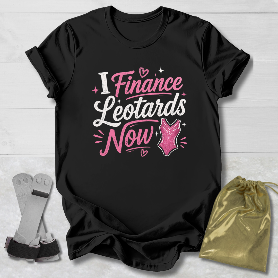 Black t-shirt with pink and white text on a light wooden surface, accompanied by socks and a gold drawstring bag.