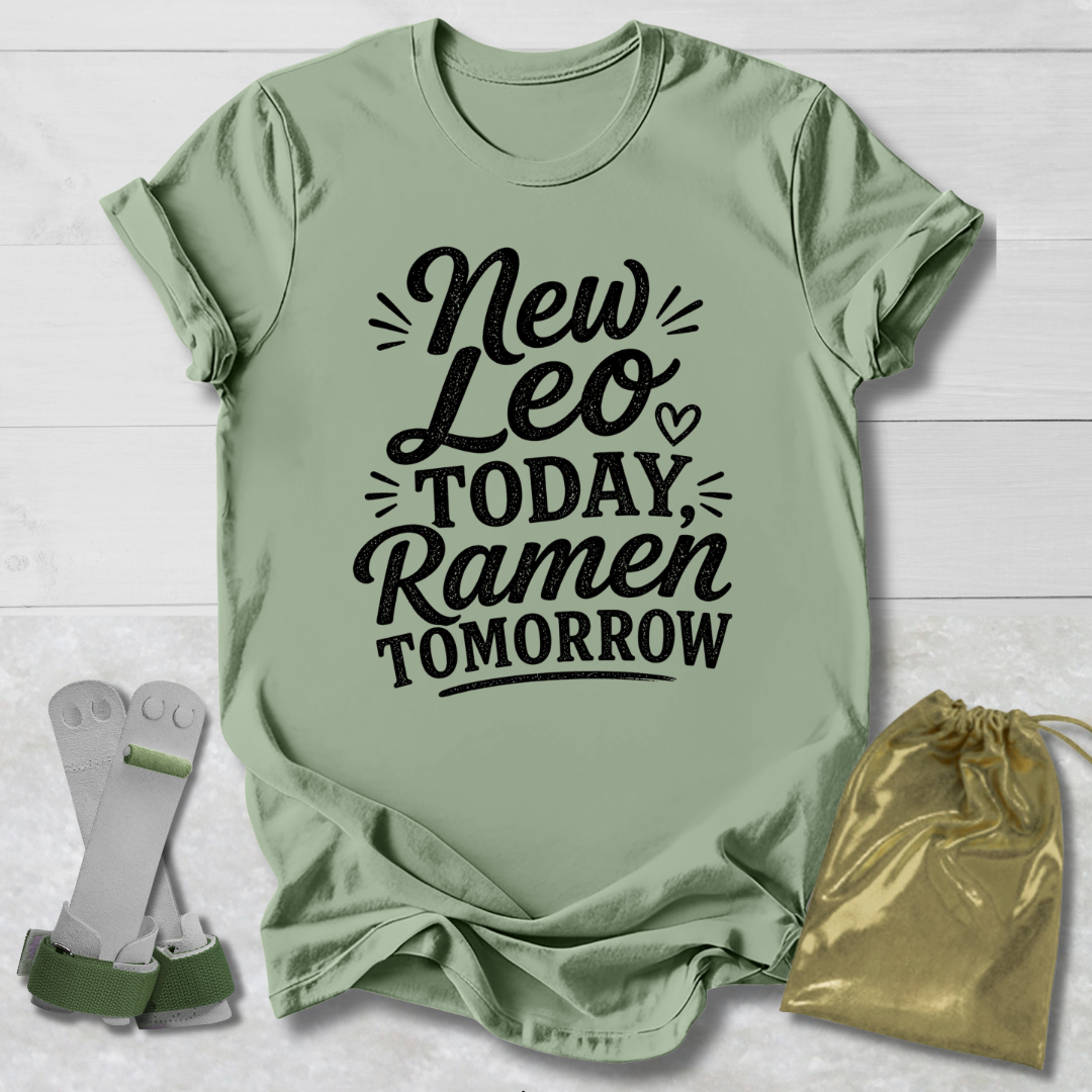Green t-shirt with text 'New Leo Today, Ramen Tomorrow' on a light wooden surface.