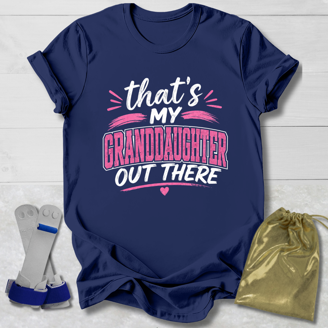 Navy blue t-shirt with 'that's my granddaughter out there' text, socks, and drawstring bag on a light wooden surface.