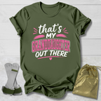 Green t-shirt with text 'That's my granddaughter out there' on a light wooden surface.