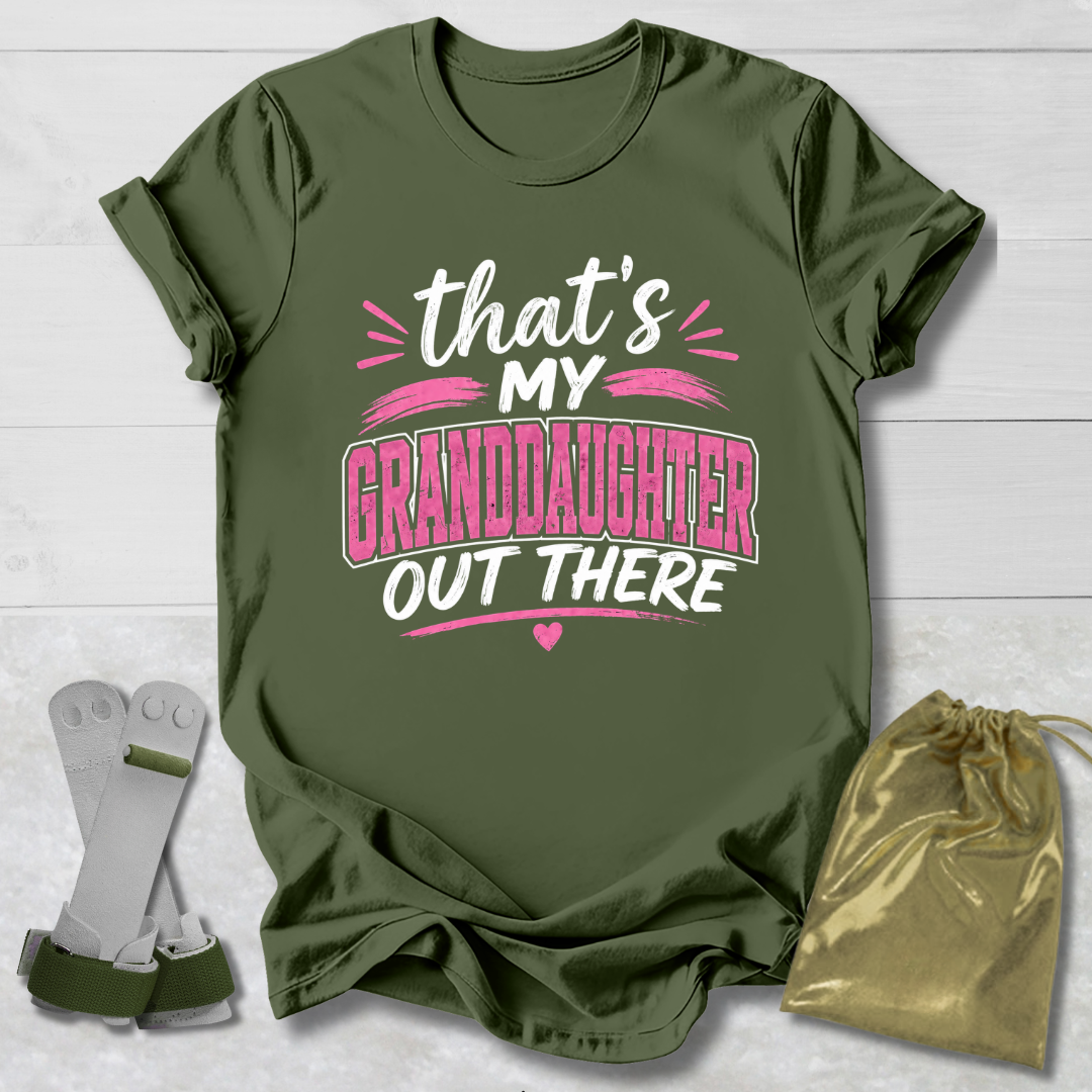 Green t-shirt with text 'That's my granddaughter out there' on a light wooden surface.