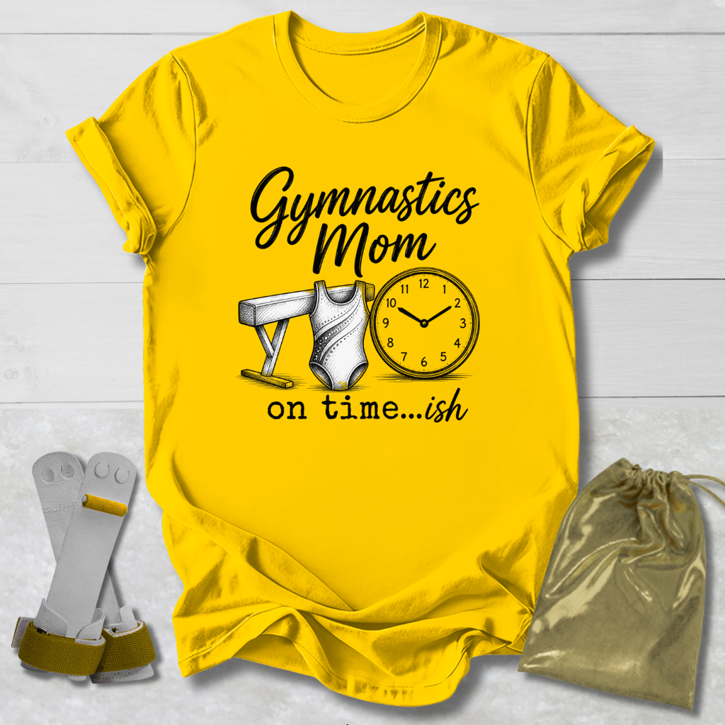 Yellow t-shirt with 'Gymnastics Mom on time...ish' design, socks, and drawstring bag on a light wooden surface.