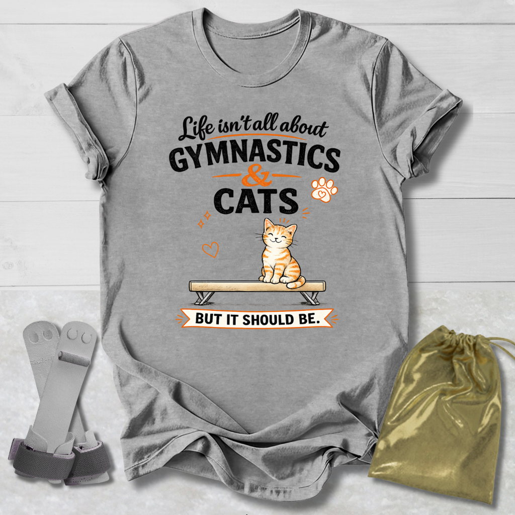 Gray t-shirt with gymnastics and cats design on a wooden surface with socks and a drawstring bag.