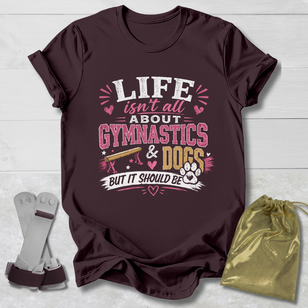 Maroon t-shirt with 'Life isn't all about Gymnastics & Dogs but it should be' text on a light wooden surface.