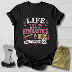 Black t-shirt with 'Life isn't all about Gymnastics & Dogs but it should be' text on a wooden surface.