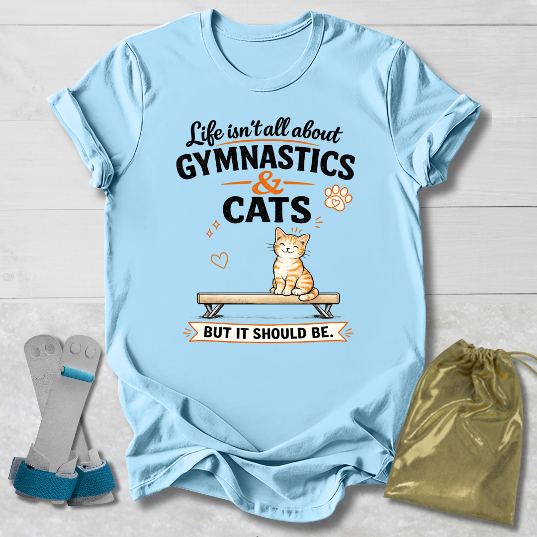 Light blue t-shirt with gymnastics and cats design on a wooden surface with socks and a drawstring bag.