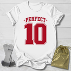 White t-shirt with 'PERFECT 10' in red on a light wooden surface, with socks and a drawstring bag.