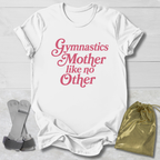 White t-shirt with pink text 'Gymnastics Mother like no Other' on a light wooden surface with socks and a drawstring bag.