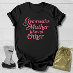 Black t-shirt with pink text 'Gymnastics Mother like no Other' on a light wooden surface.
