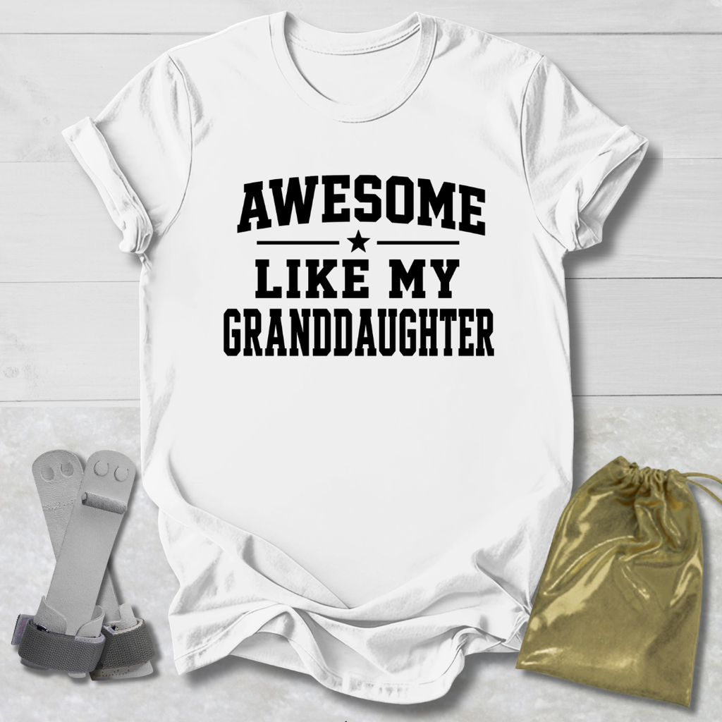 White t-shirt with 'Awesome like my granddaughter' text on a light wooden surface.