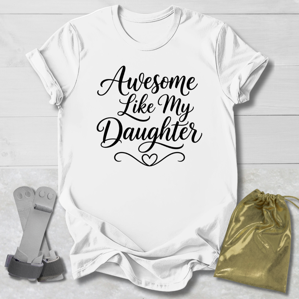 White t-shirt with 'Awesome Like My Daughter' text on a light wooden surface with socks and a drawstring bag.