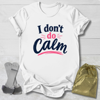 White t-shirt with 'I don't do Calm' text, socks, and drawstring bag on a light wooden surface