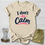 Beige t-shirt with 'I don't do calm' text, socks, and drawstring bag on a light wooden surface
