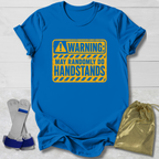 Blue t-shirt with a yellow warning sign graphic, socks, and a drawstring bag on a light wooden surface.