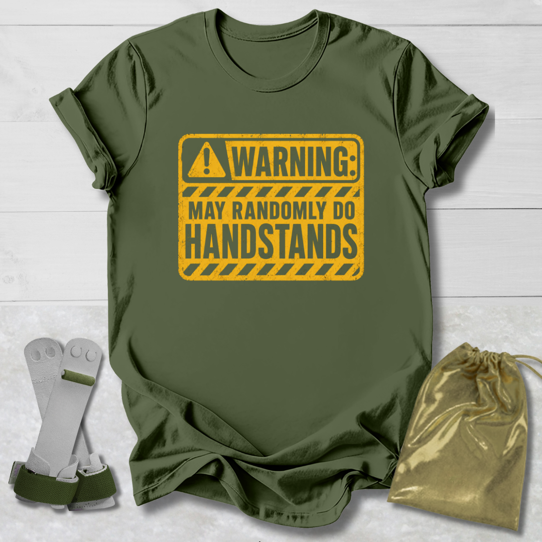 Green t-shirt with a yellow warning sign graphic on a light wooden surface.