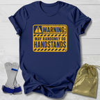 Navy blue t-shirt with yellow warning sign graphic on a light wooden surface.