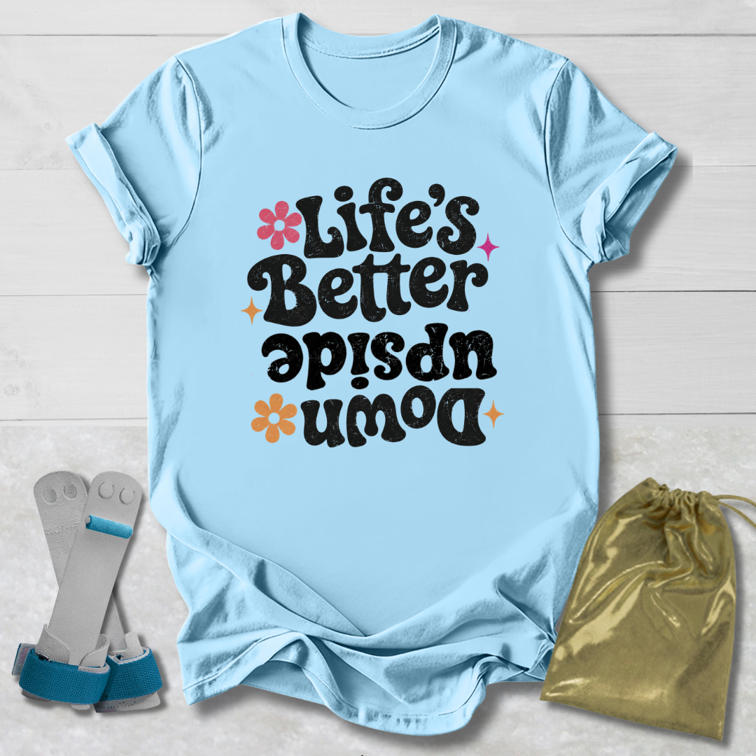 Light blue t-shirt with 'Life's Better Upside Down' text, socks, and drawstring bag on a light wooden surface.