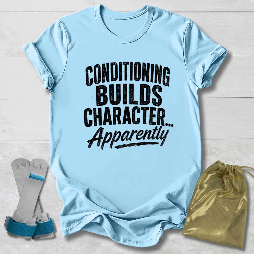 Light blue t-shirt with black text 'Conditioning Builds Character... Apparently' on a light wooden surface.