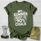 Green t-shirt with 'My Summer Body is 90% Chalk' text on a wooden surface with socks and a drawstring bag.