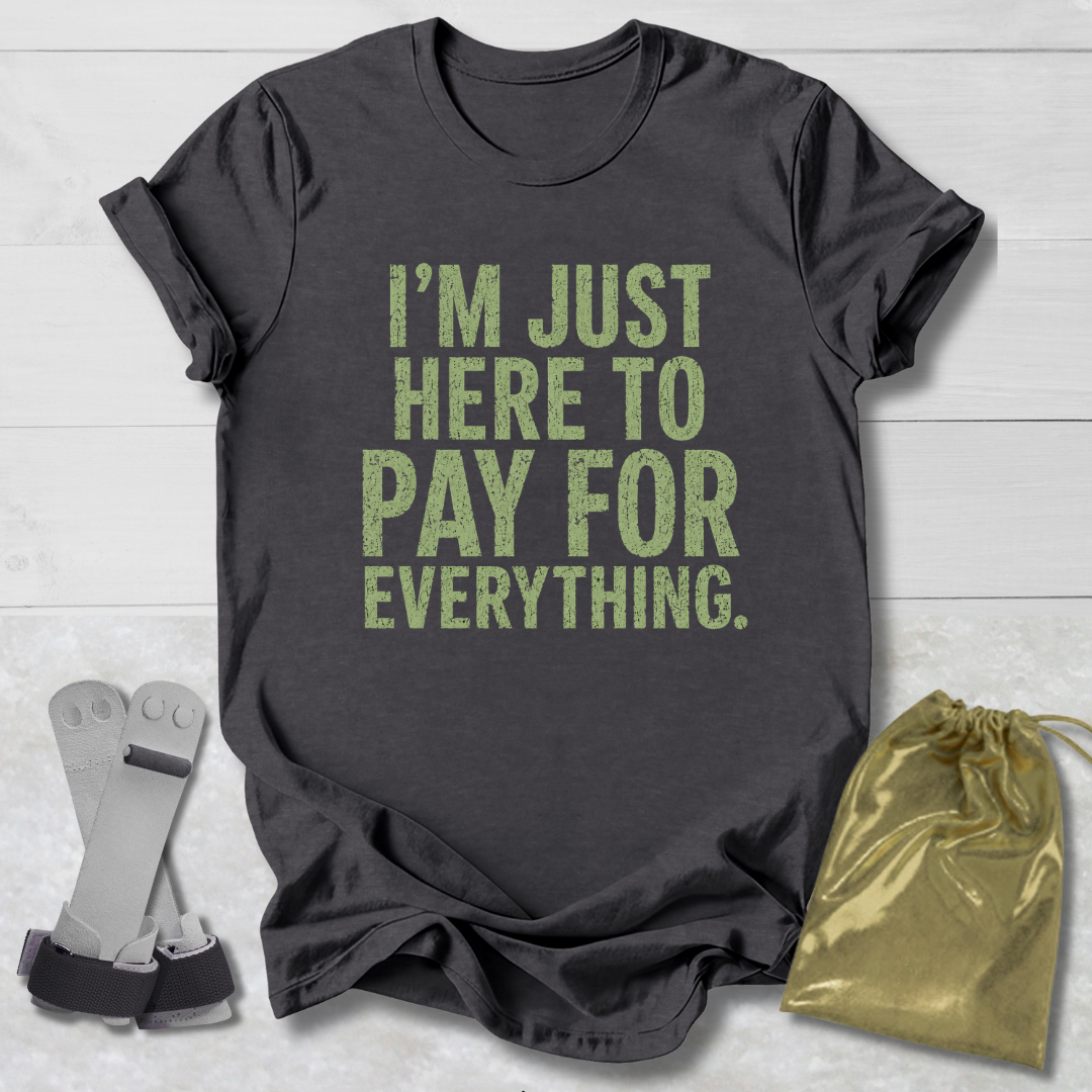 Gray t-shirt with 'I'm just here to pay for everything' text, socks, and drawstring bag on a light wooden surface.