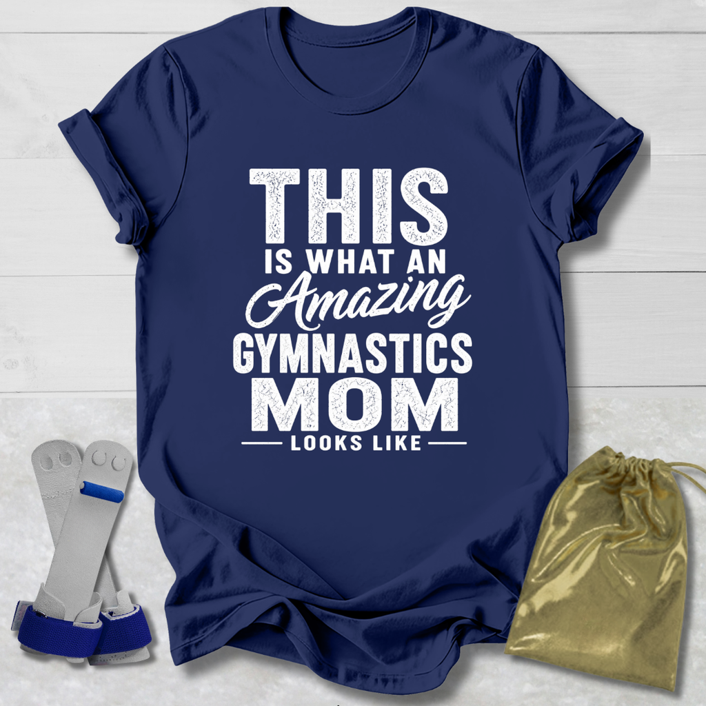 Navy blue t-shirt with white text 'This is what an amazing gymnastics mom looks like' on a light wooden surface.