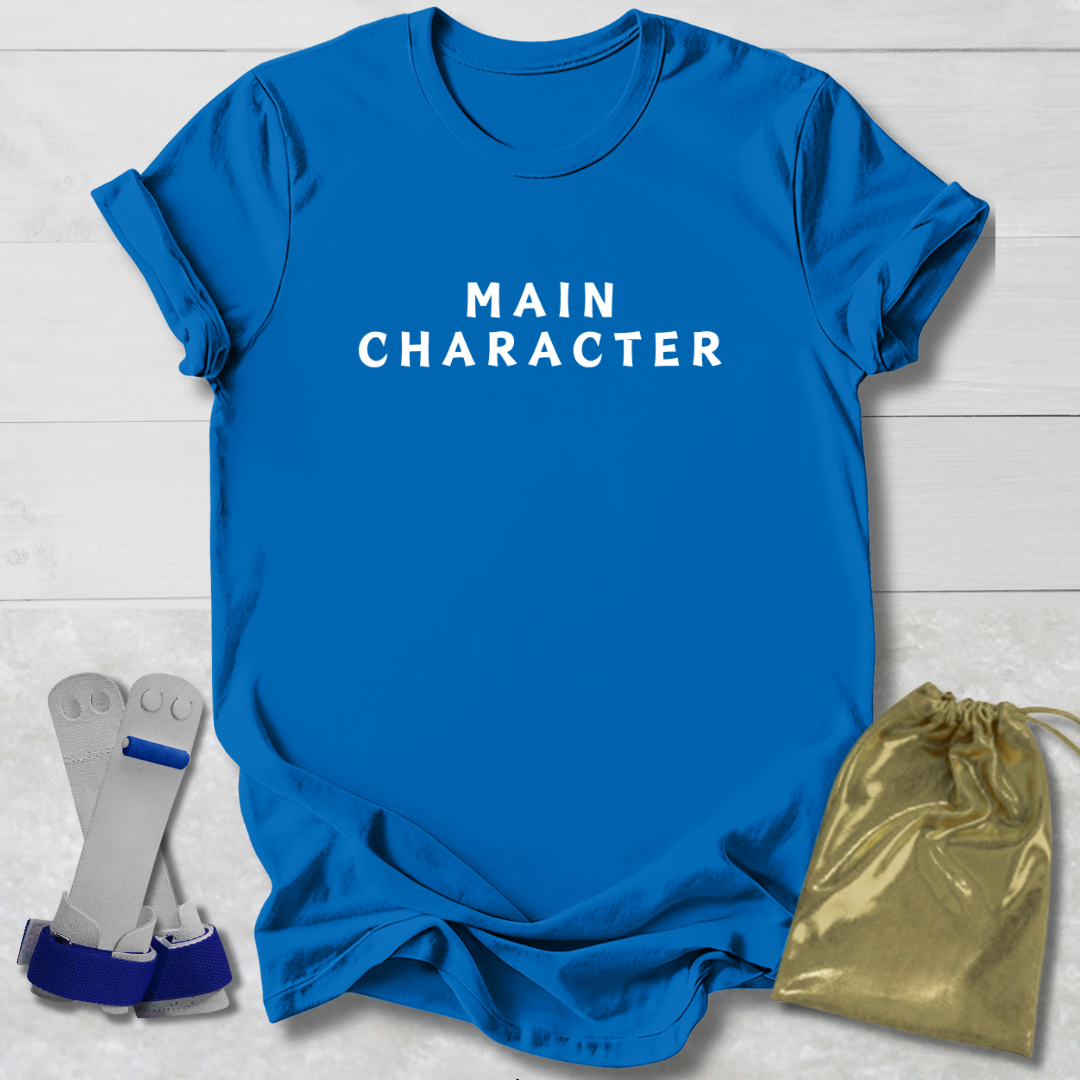 Blue t-shirt with 'MAIN CHARACTER' text, socks, and drawstring bag on a light wooden surface