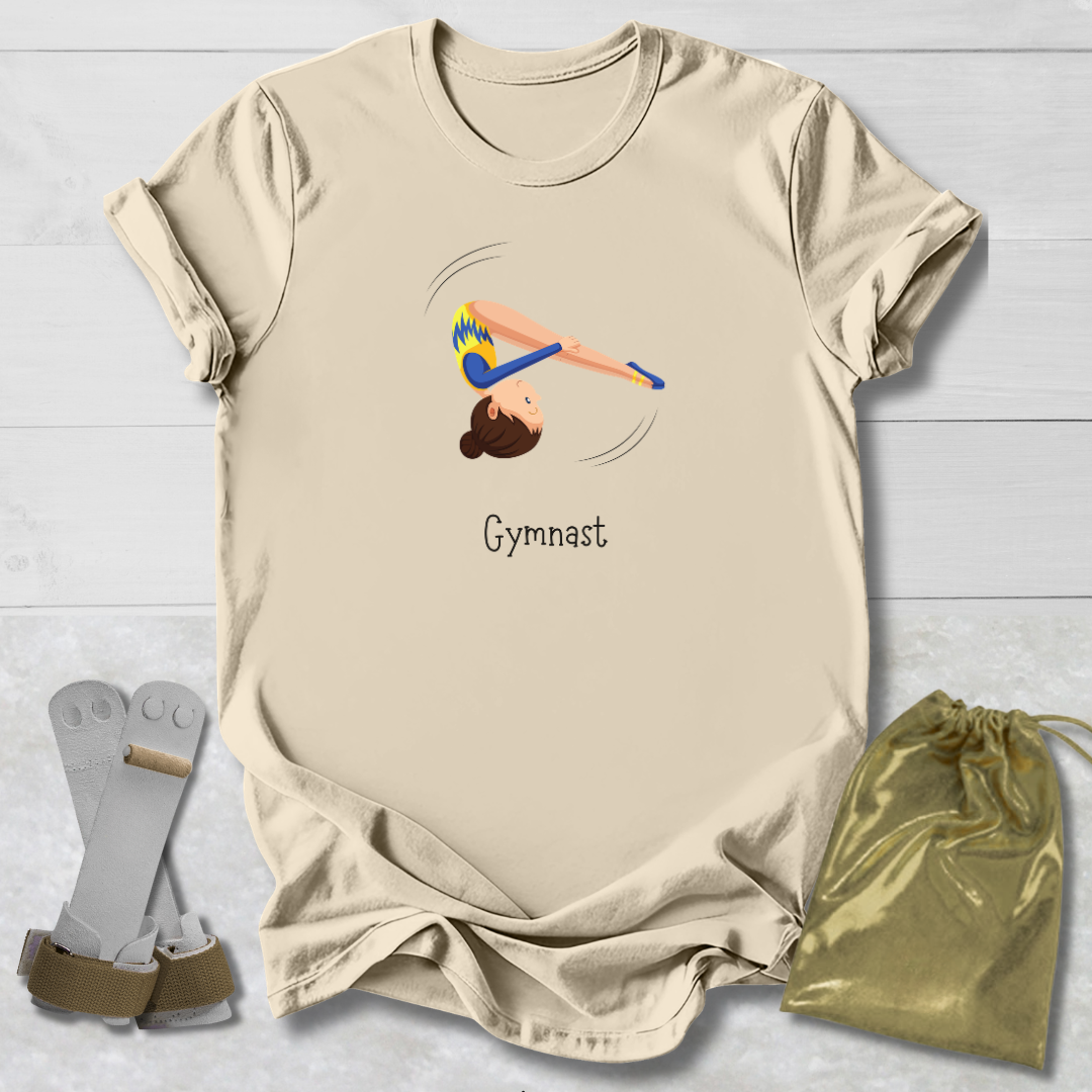 Beige t-shirt with gymnast design and text, socks, and drawstring bag on a light wooden surface